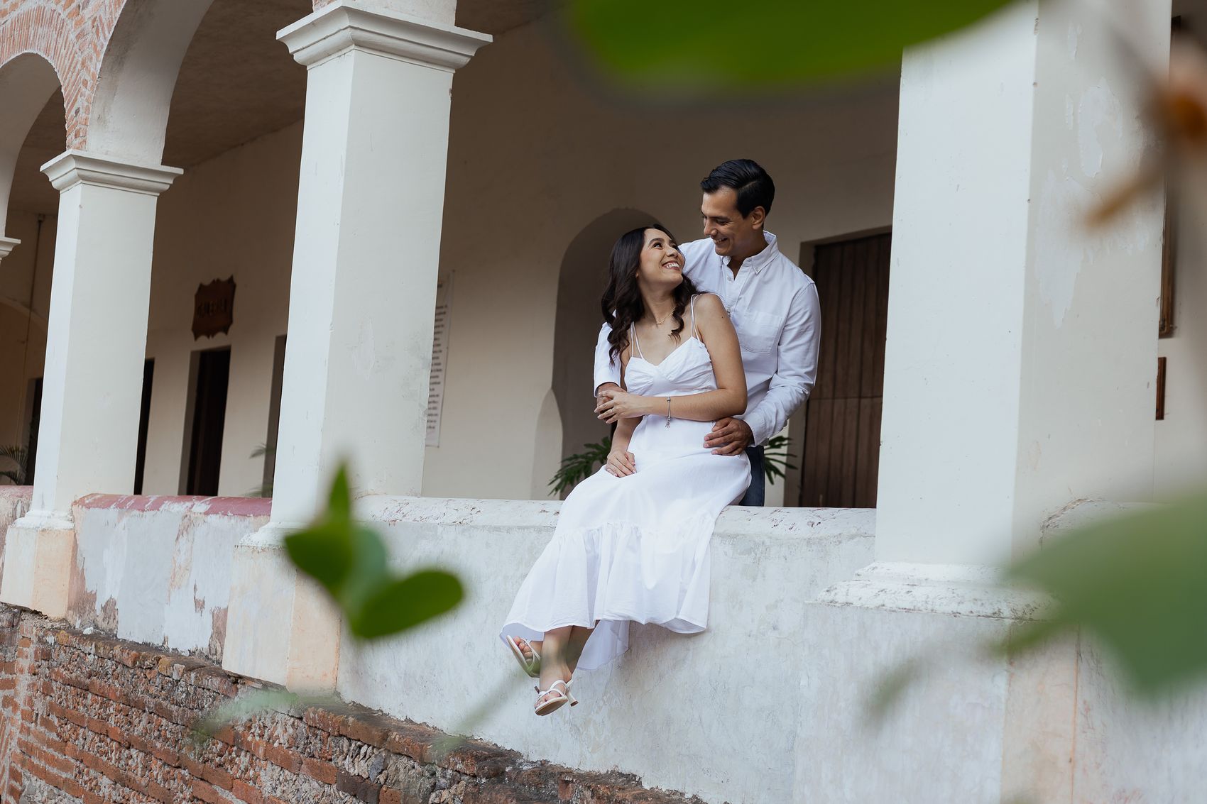 Alma y Pedro sentados en el muro de la hacienda